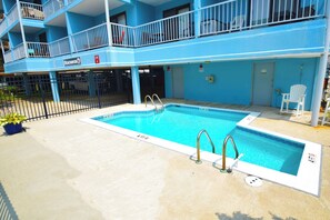 A swimming pool with a blue building in the background.