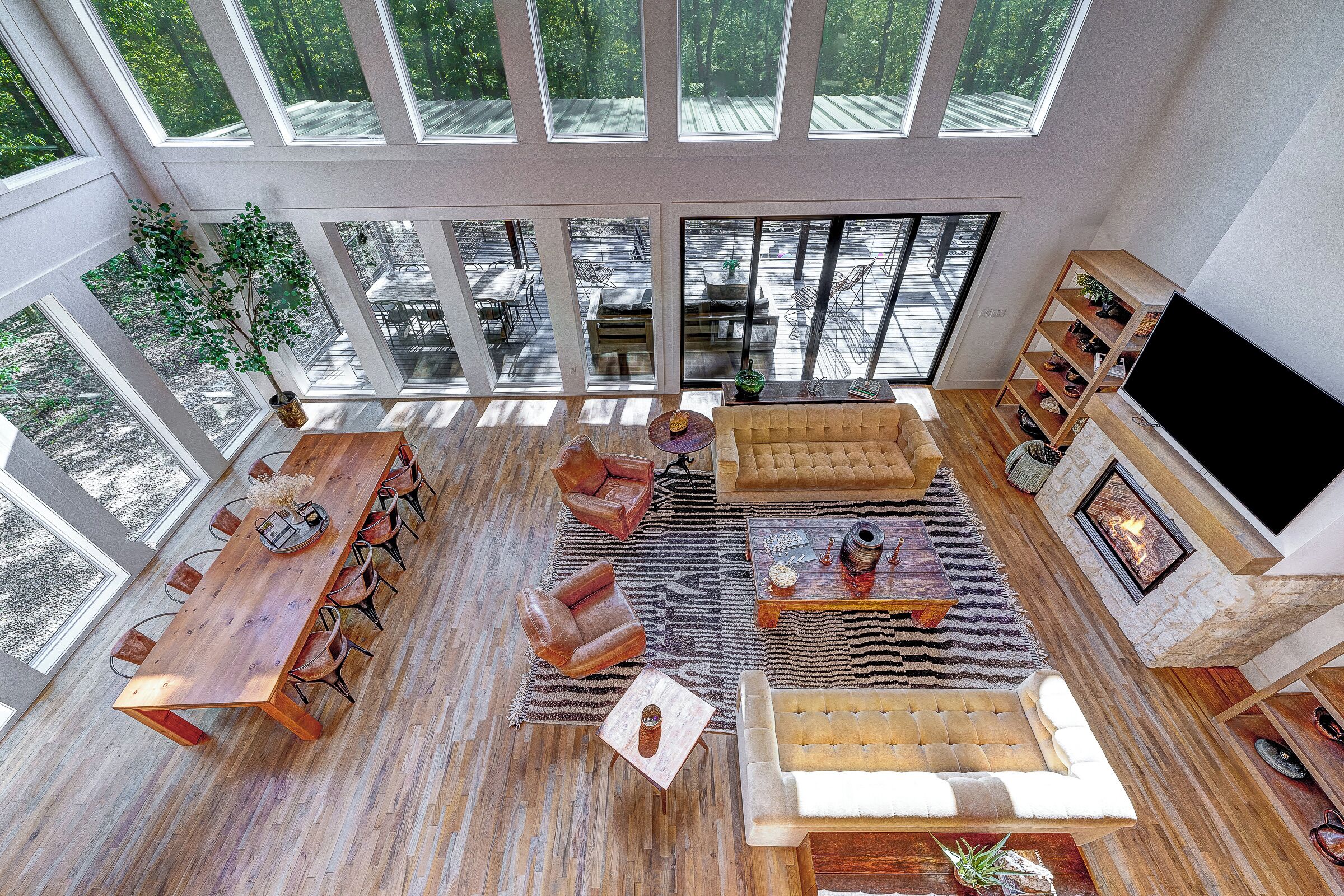 A spacious living area with a large wooden dining table, leather sofas, and a fireplace.