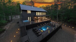 A two-story house with a deck, outdoor pool, and multiple windows.