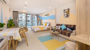 Una habitación de hotel moderna con cama, sofá, mesa de comedor y sillas.