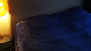 A bed with a dark blue cover, a wall-mounted macrame decoration, and a bedside lamp. - 1 bedroom apt. of an Artist photographer close to Cannes Croisette (Cannes)