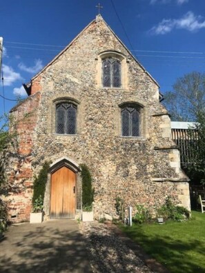 Stunning historic building with a central tower and beautifully manicured grounds.