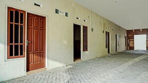 A building with a tiled floor and multiple doors and windows. - OYO Life  92393 Namimart Syariah 1 (Kediri)