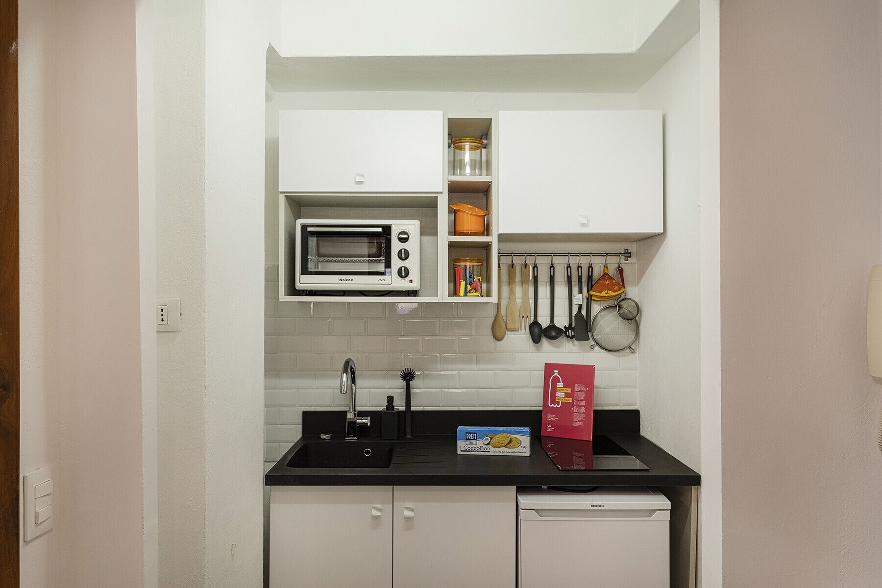 A compact kitchen with a built-in oven, a sink, and a dishwasher.