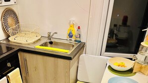 A modern kitchen with a sink, a dish rack, and a bowl of fruit on the counter. - Very Lovely and Central 1-bed Apartment in London (London)