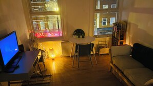 A cozy living room with a dining table, a sofa, a TV, and a window with a view of buildings. - Very Lovely and Central 1-bed Apartment in London (London)