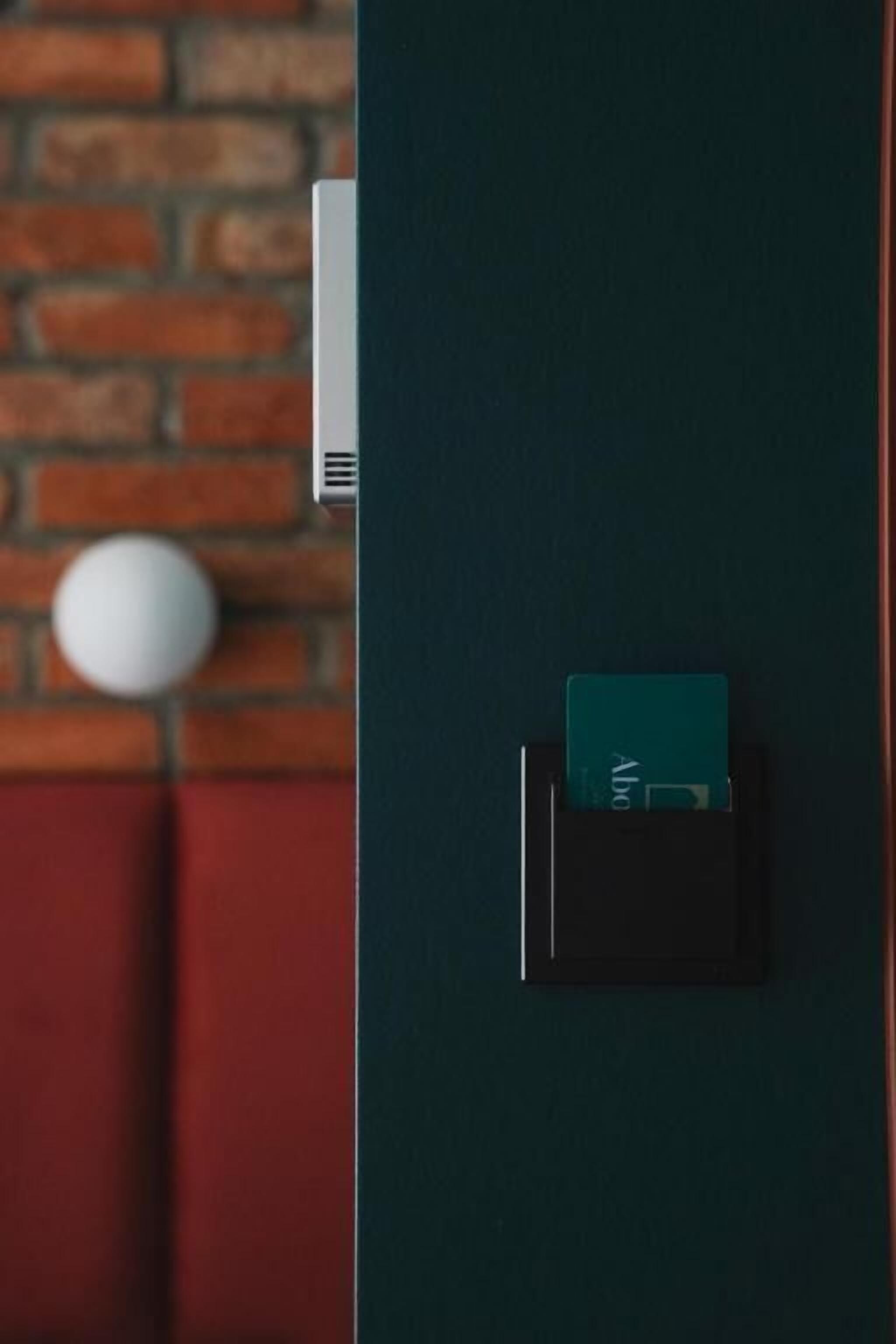 A door with a card reader and a white object on the wall.