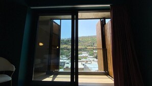 A room with a large sliding glass door leading to a balcony. - About Sololaki (Tbilisi)