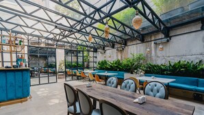 A restaurant with a glass ceiling, wooden tables, and blue cushioned seating. - About Sololaki (Tbilisi)