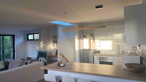A modern kitchen with a central island, built-in appliances, and a dining area with a sofa and chairs.