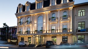 Un hôtel de luxe doté de nombreux balcons, de grandes fenêtres et d’une entrée bien éclairée.