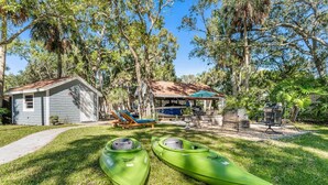 A small house with a covered patio, two kayaks, and a swimming pool. - Manatee & kayak friendly waterfront cottage (Ormond Beach)