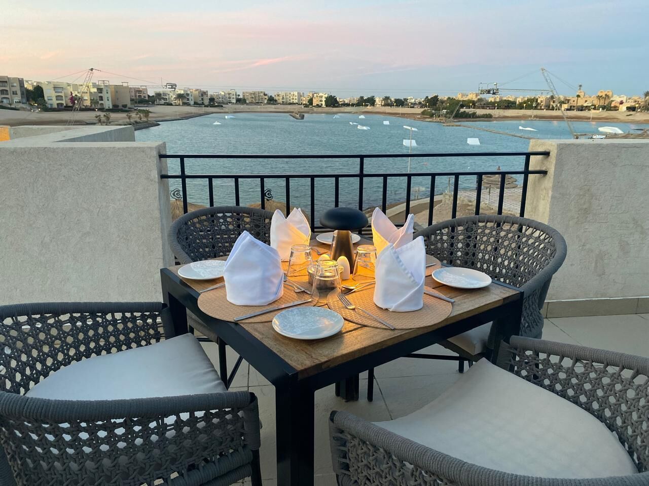 Mesa para dos con vista al mar y edificios al fondo.
