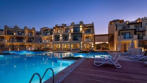 A modern hotel with a swimming pool, lounge chairs, and a wooden deck. - Creek Hotel and Residences El Gouna (El Gouna)