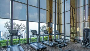 A gym with treadmills, dumbbells, and exercise equipment.