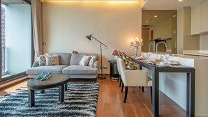 A modern living room with a sofa, coffee table, and dining area.