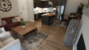 A modern living room with a sofa, coffee table, and a small potted plant.