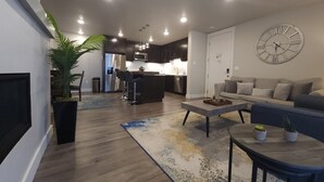 A modern living room with a sofa, coffee table, and a large wall clock. - SageCreek "Moab" Hot Tubs Heated Pool - Condo D3 (Moab)