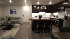Una cocina moderna con gabinetes oscuros, un refrigerador de acero inoxidable y un microondas.