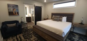 A bedroom with a bed, bedside tables, a chair, a desk, a mirror, and a window. - "Aztec Hideout" Sage Creek Moab Condo F2 - Pool (Moab)