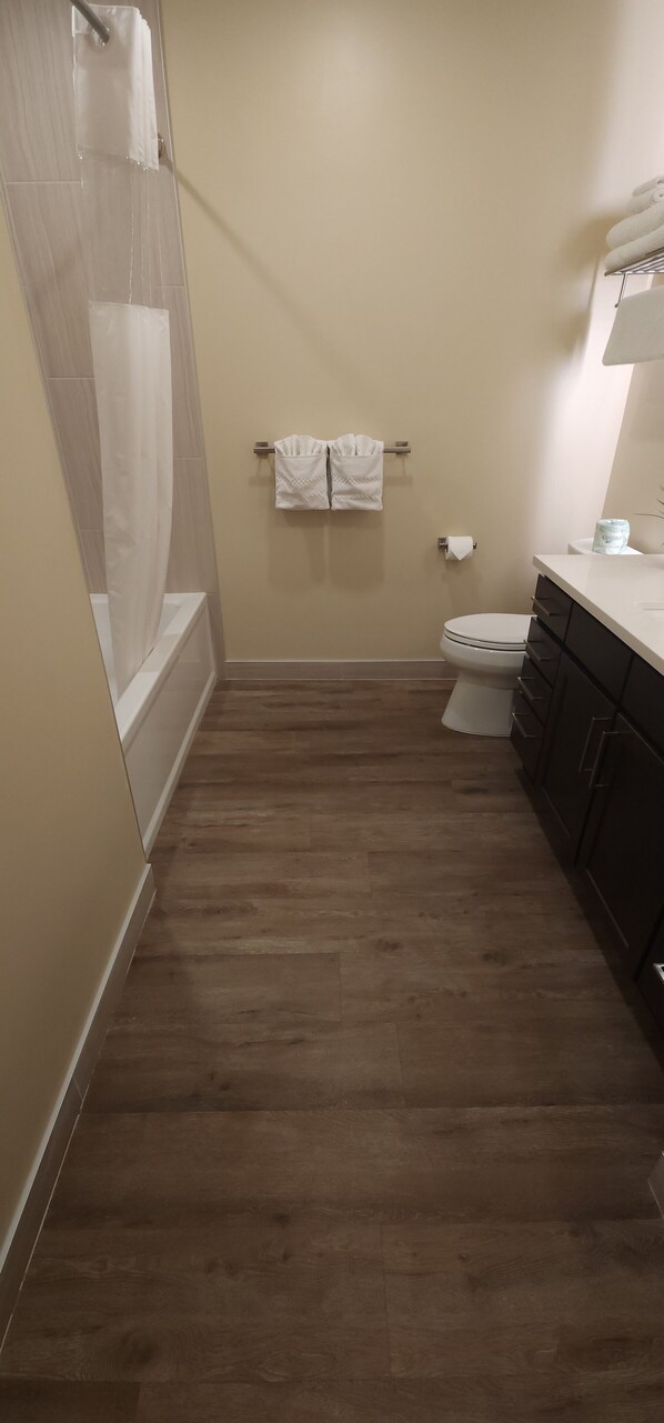 A narrow bathroom with a shower, toilet, and dark cabinets. - Sage Creek "Moab Reflections F2" - Stunning Pool (Moab)