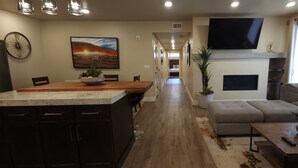 A modern living room with a sofa, a coffee table, and a TV mounted on the wall. - Sage Creek Resort at Moab - Quad Rental F5-6-7-8 (Moab)