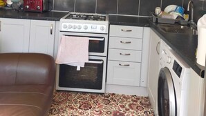 Una cocina compacta con estufa, horno, microondas y lavadora.