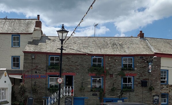 A stone building with a sign for 'Luccifer Inn' and a '24 Hour Pay Car Park' sign.