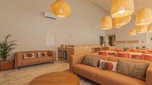 A modern living room with a sofa, coffee table, and dining area with chairs and tables. - Silves History Guest House (Silves)