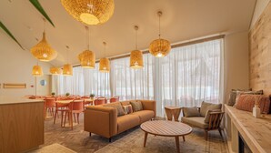 A modern living room with a sofa, coffee table, and dining area with chairs. - Silves History Guest House (Silves)