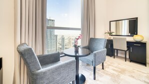 A modern hotel room with a city view, a round table with two chairs, a desk with a chair, and a large mirror on the wall. - High Floor 2BR w/ a View of the Dubai Marina,Near fr. the Beach , Shams 1, JBR (Dubai)