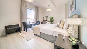 A modern hotel room with a large bed, a desk, a chair, and a potted plant. - High Floor 2BR w/ a View of the Dubai Marina,Near fr. the Beach , Shams 1, JBR (Dubai)