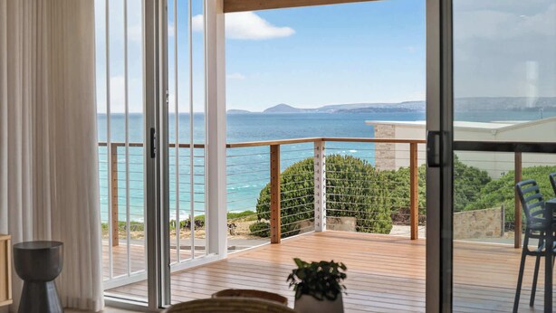 Ein Balkon mit Blick auf das Meer und das entfernte Land.