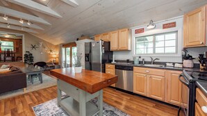 A spacious kitchen with wooden cabinets, a central island, and modern appliances. - Dog Friendly Cottage w/ Dock & Shuffleboard (Swanton)