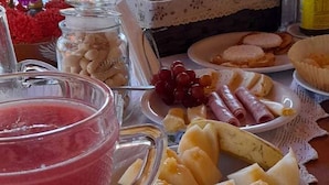 Une table avec une assiette de tranches de bananes, un verre de smoothie rose et divers en-cas.