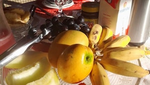 Une table avec des fruits, un verre et une boîte de pirojki.