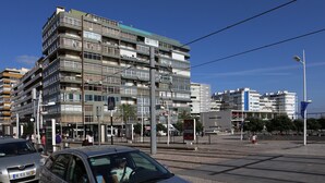 A multi-story building with balconies, a tram line, and a pedestrian area. - Room for Rent in Almada/lisbon (Almada)