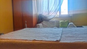 A bedroom with a bed, a wardrobe, and a window with sheer curtains. - Room for Rent in Almada/lisbon (Almada)