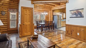 A spacious log cabin interior with a dining area, kitchen, and a loft bedroom. - Golf View 2 Bedroom Cabin by RedAwning (Pigeon Forge)