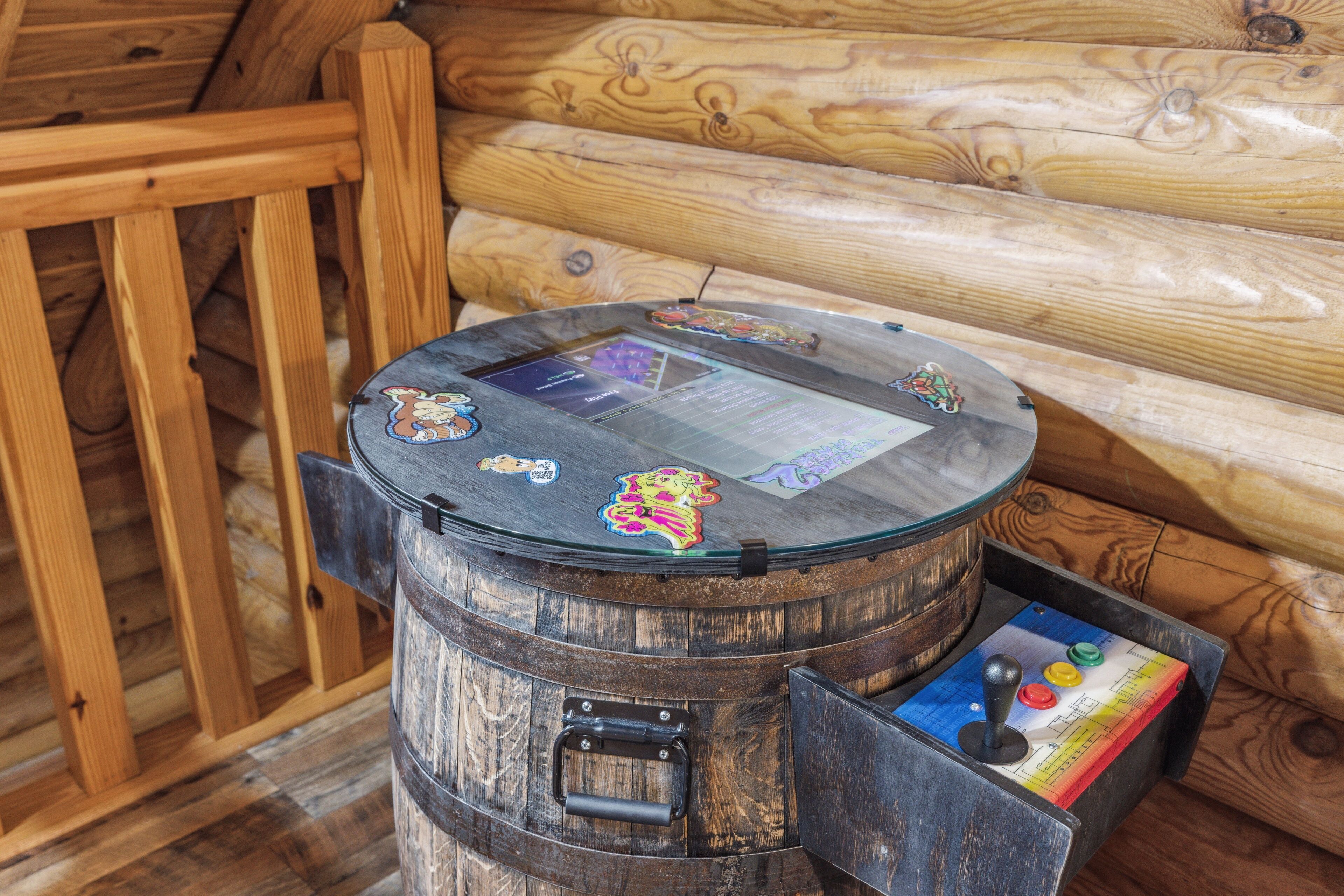 A wooden barrel with a table on top, featuring a colorful game board and a small drawer with a game piece.