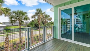 A balcony with a view of palm trees and a residential area.