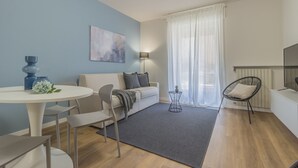 A modern living room with a sofa, chairs, a dining table, and a TV. - La casa del Sarto_varennaholidays (Perledo)