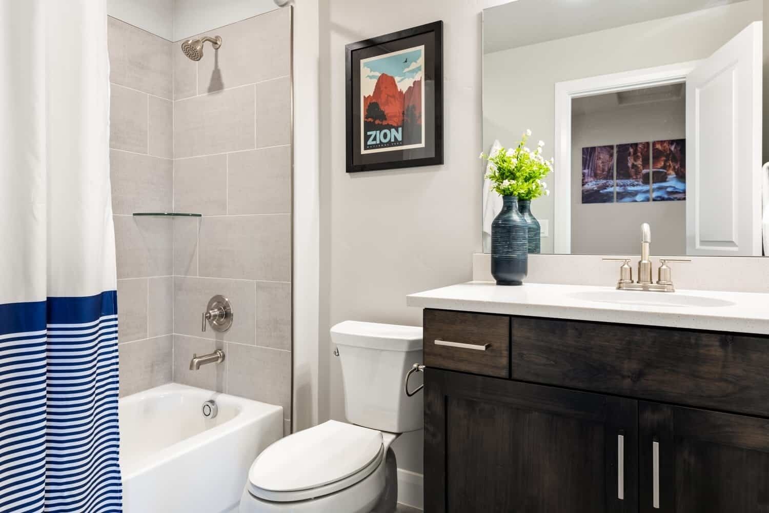 A modern bathroom with a bathtub, toilet, and vanity.