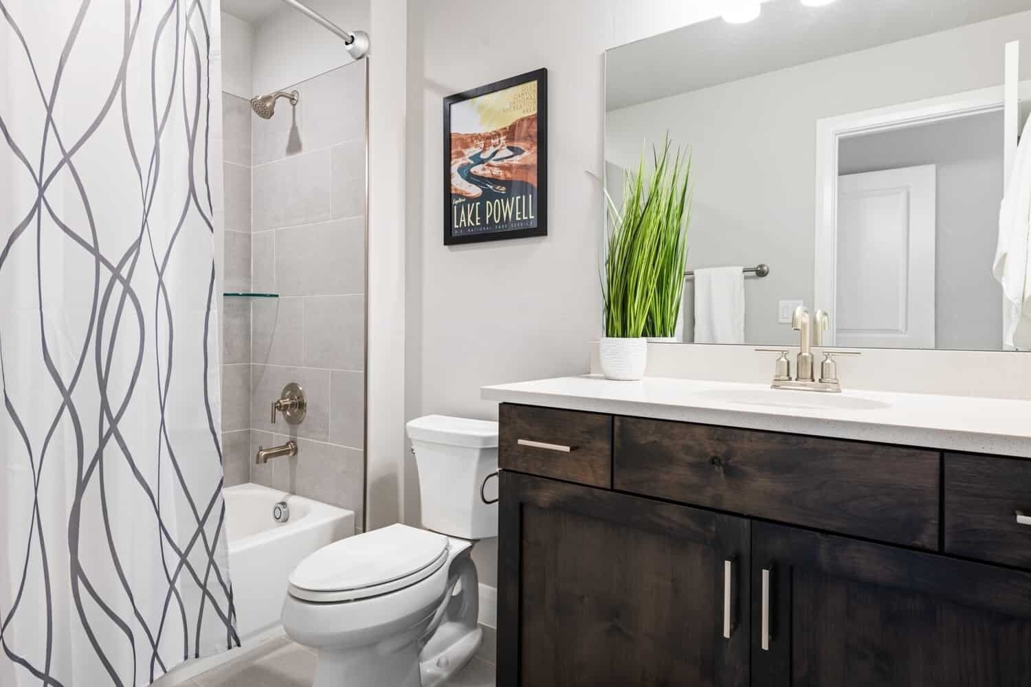 Een moderne badkamer met douche, toilet en wastafel.