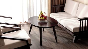 A modern living room with a round wooden coffee table, a beige sofa, and two armchairs.
