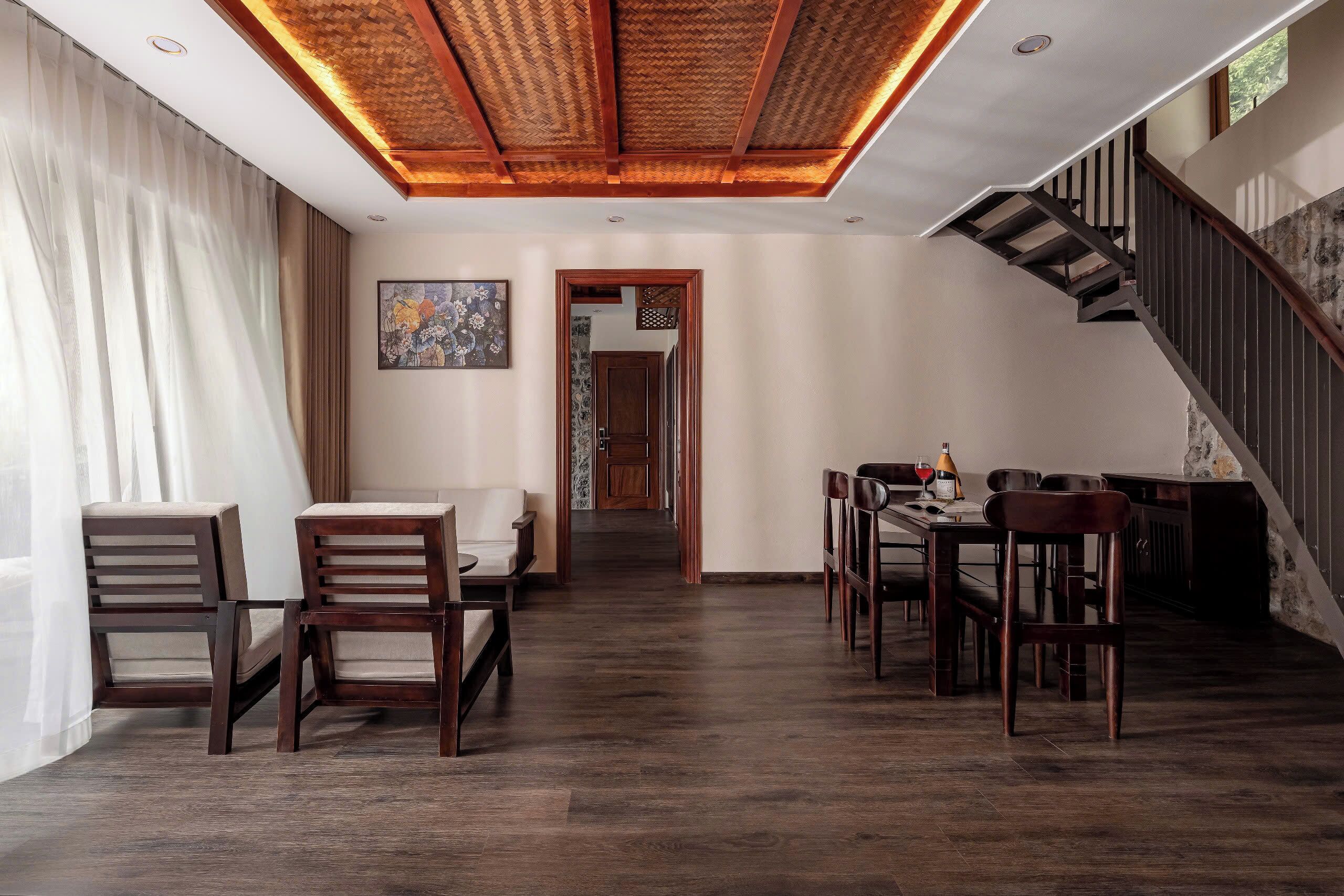 A spacious dining area with a wooden ceiling and a staircase leading to another level.