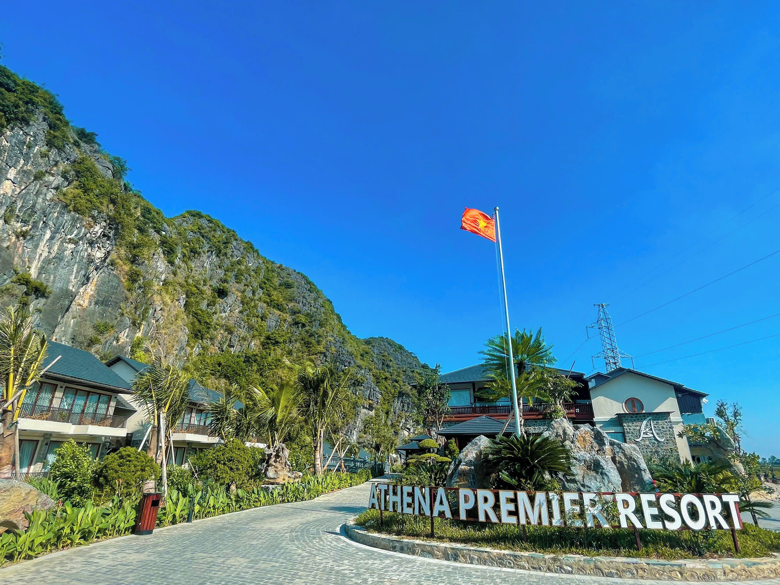 Señal de Athena Premier Resort con montañas al fondo y cielo despejado.