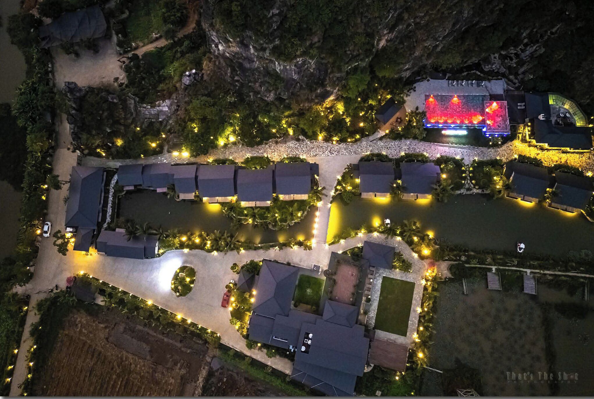 An aerial view of a resort with multiple buildings, pathways, and illuminated areas.
