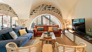 A cozy living room with a sofa, a coffee table, and wicker chairs. - Garriguella- Roses – Pool Costa Brava House (Garriguella)