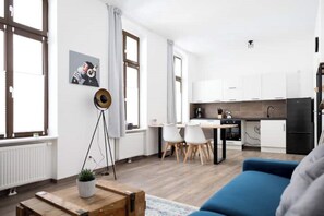 Um apartamento moderno com sala de jantar, cozinha e sala de estar.